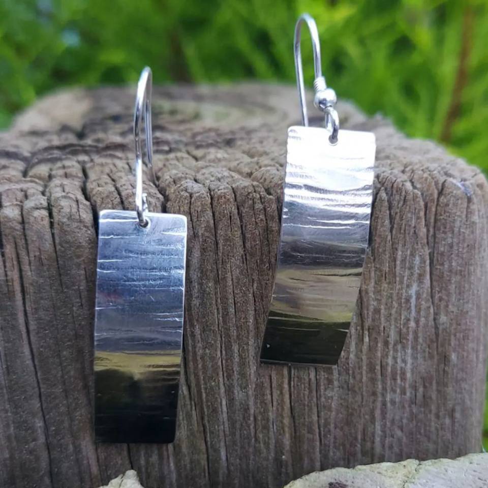 textured sheet drop earrings on wooden log